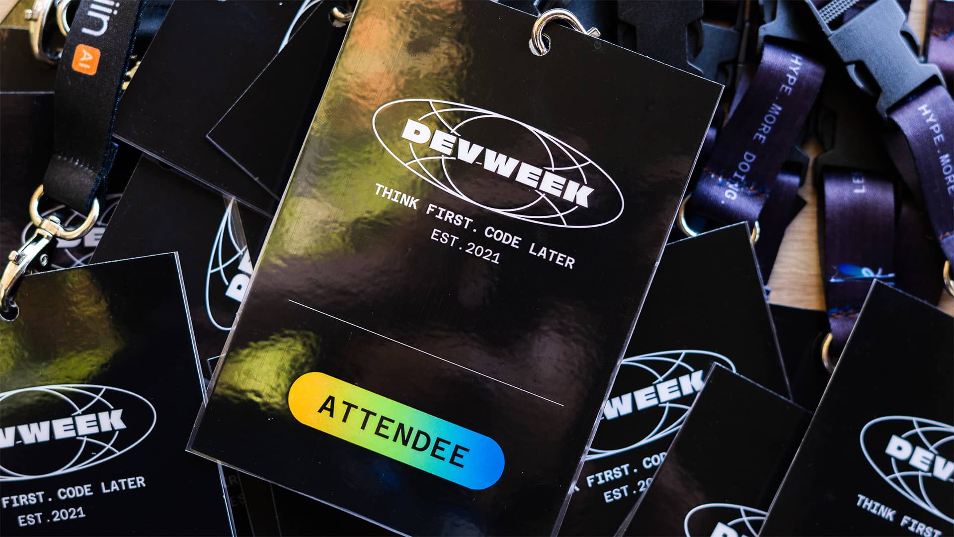 Black glossy DevWeek attendee credentials and lanyards